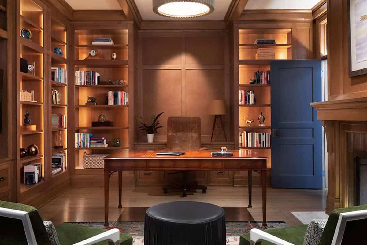 Library desk in front of backlit oak bookshelves