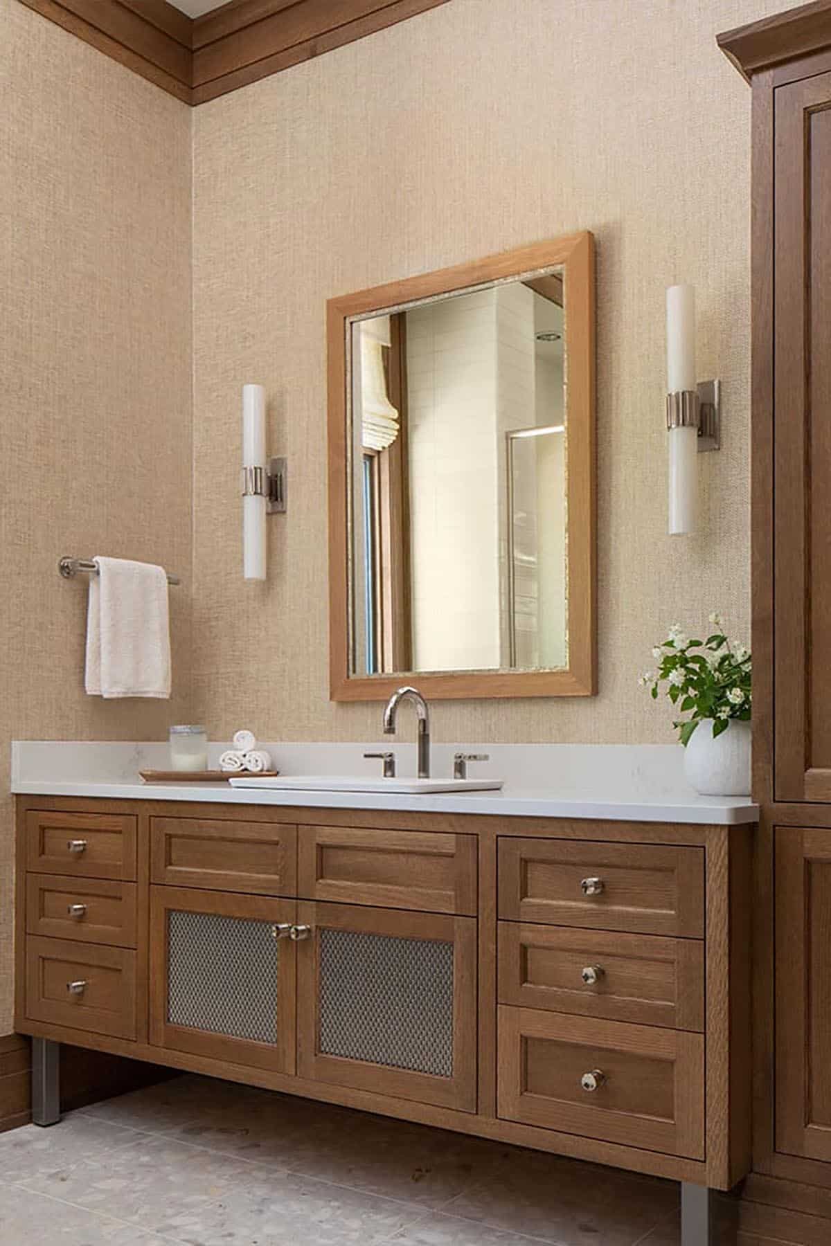 Oak bathroom vanity with mesh door panels and grasscloth walls