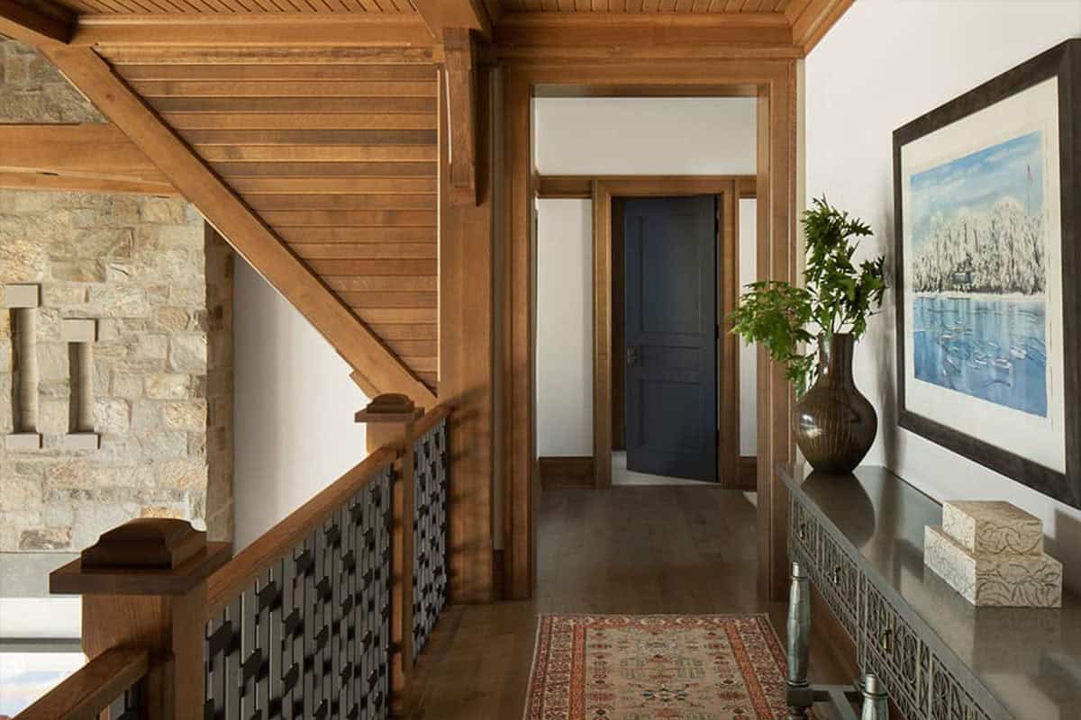 Upstairs hallway with stone wall, fretwork railing and console table