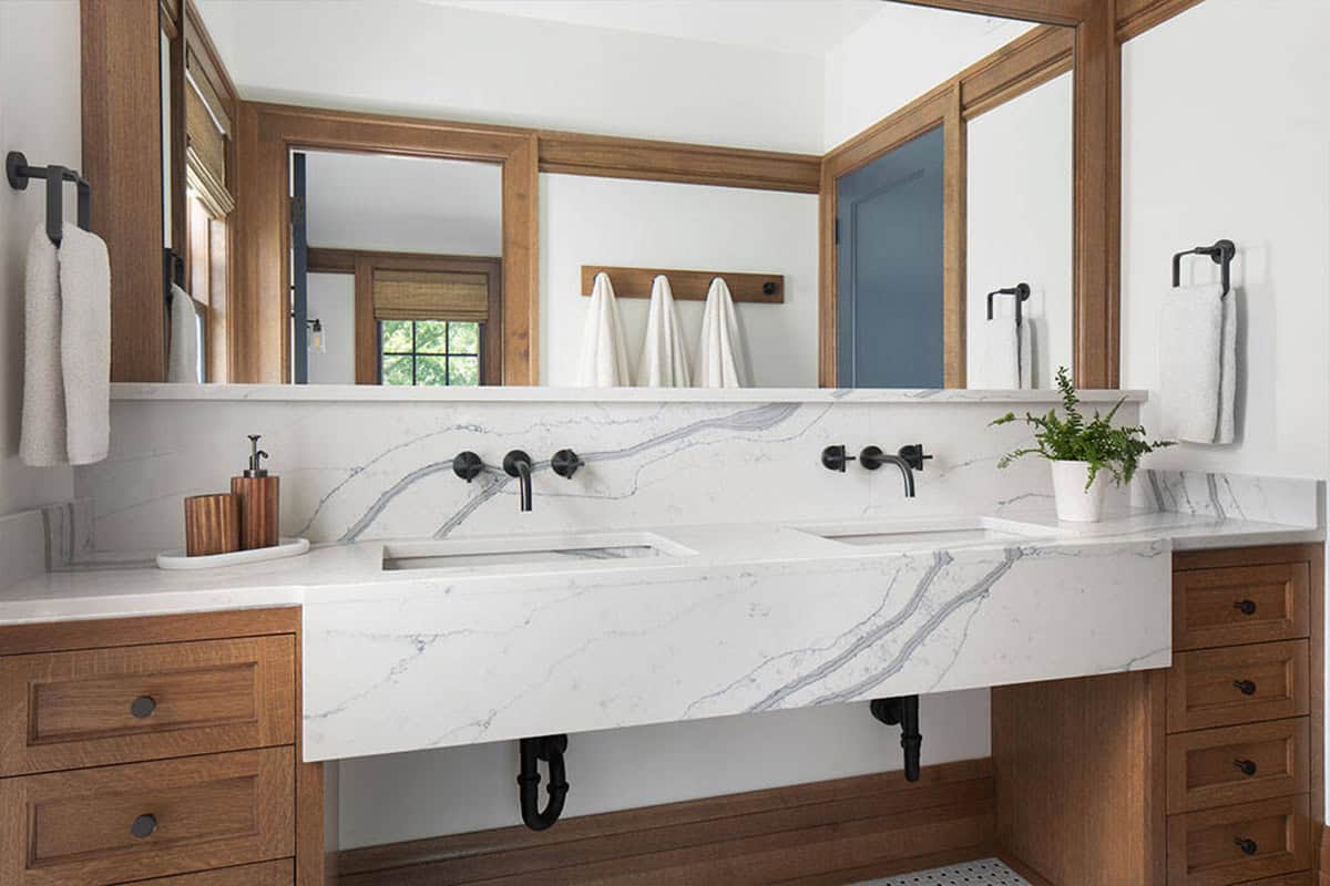 Floating marble double sink vanity with black wall-mounted faucets