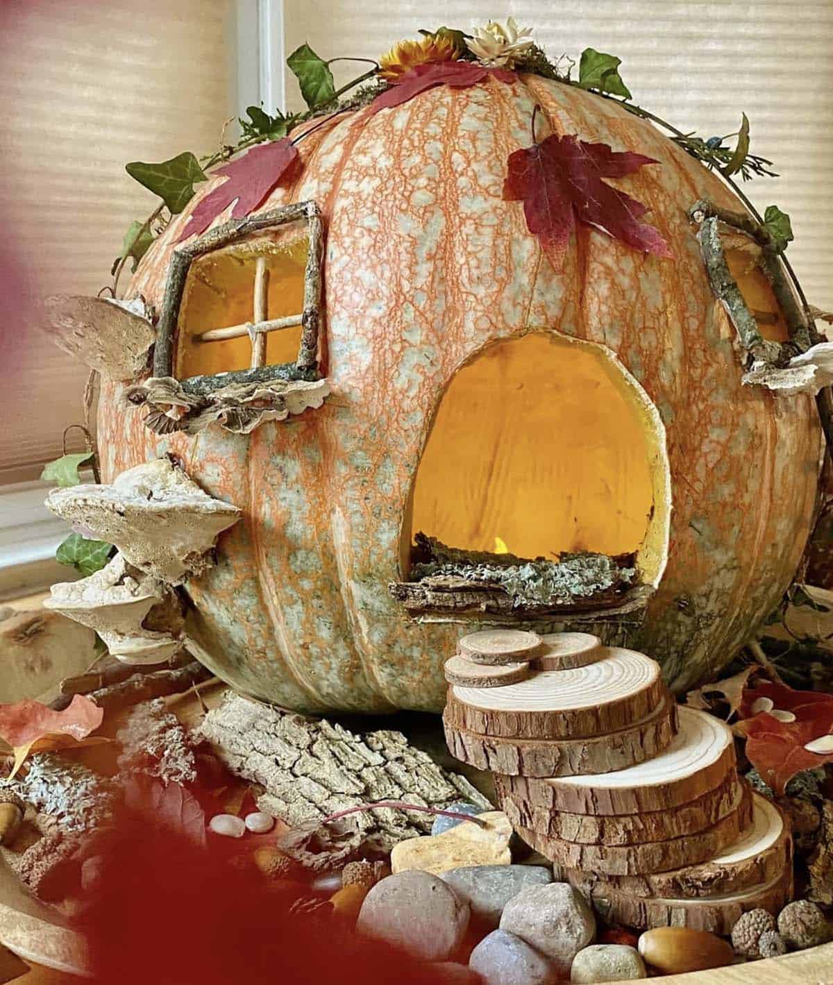 heirloom jack-o’-lantern with glowing arched doorway, twig windows, shelf mushrooms, ivy, and wood slice stairs