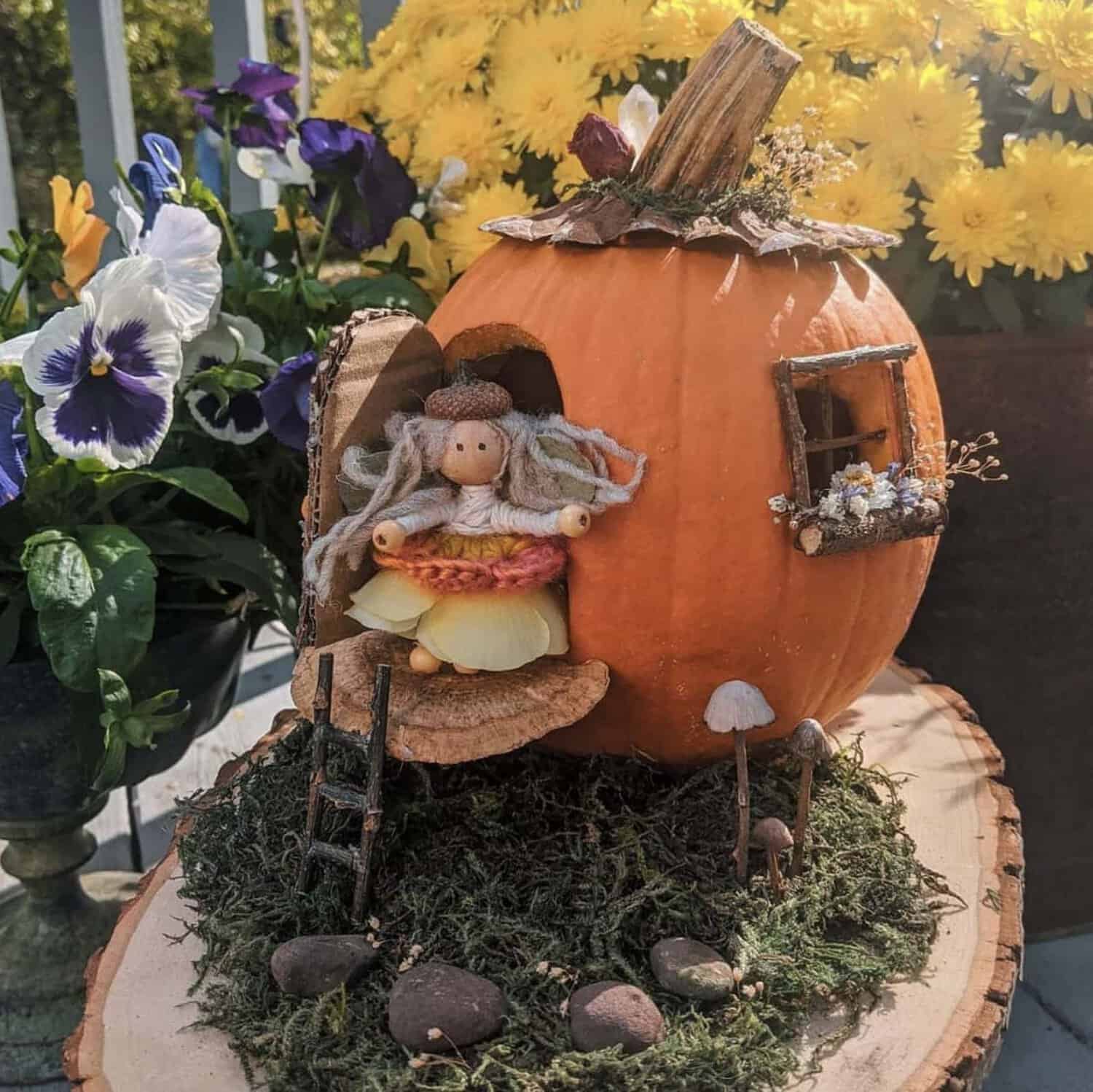 handmade fairy doll with acorn cap hat and petal skirt standing in the open twig door of a fairy house pumpkin