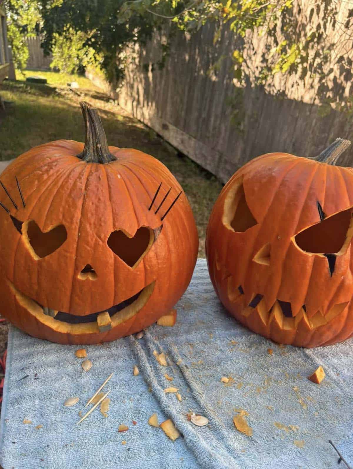 his and hers pumpkins, one lovestruck with heart eyes, lashes and a one-tooth grin, the other grumpy with angry eyes and a jagged scowl