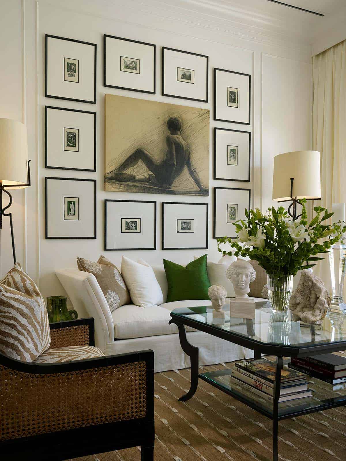 Gallery wall of ten matted prints around a large charcoal drawing above a white sofa