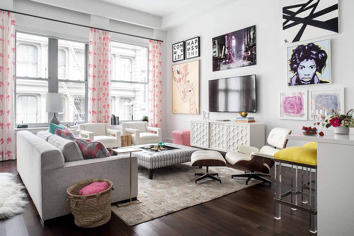 Loft living room with a gallery wall of colorful paintings and prints surrounding a wall-mounted TV