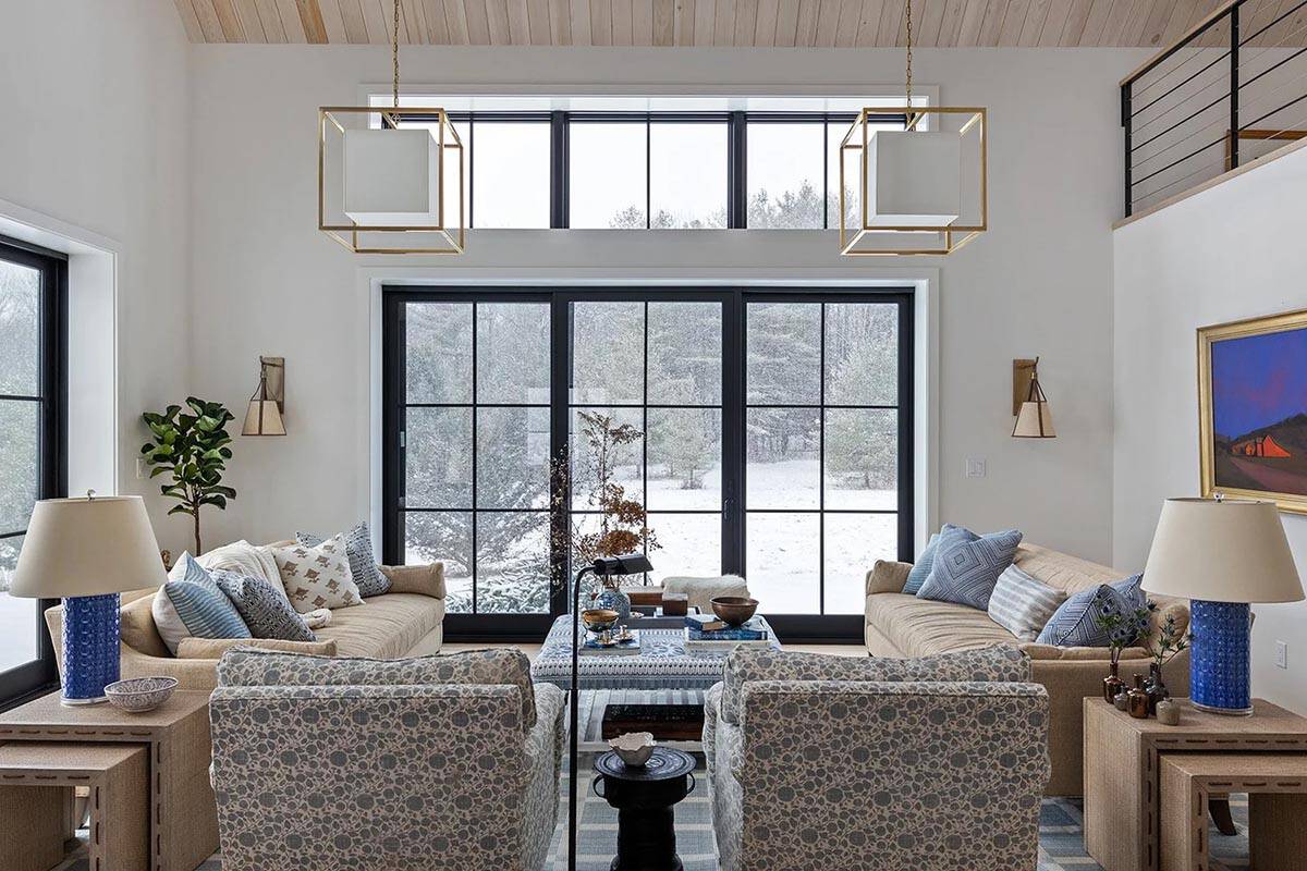 Symmetrical seating area facing a wall of black-framed glass doors and clerestory windows