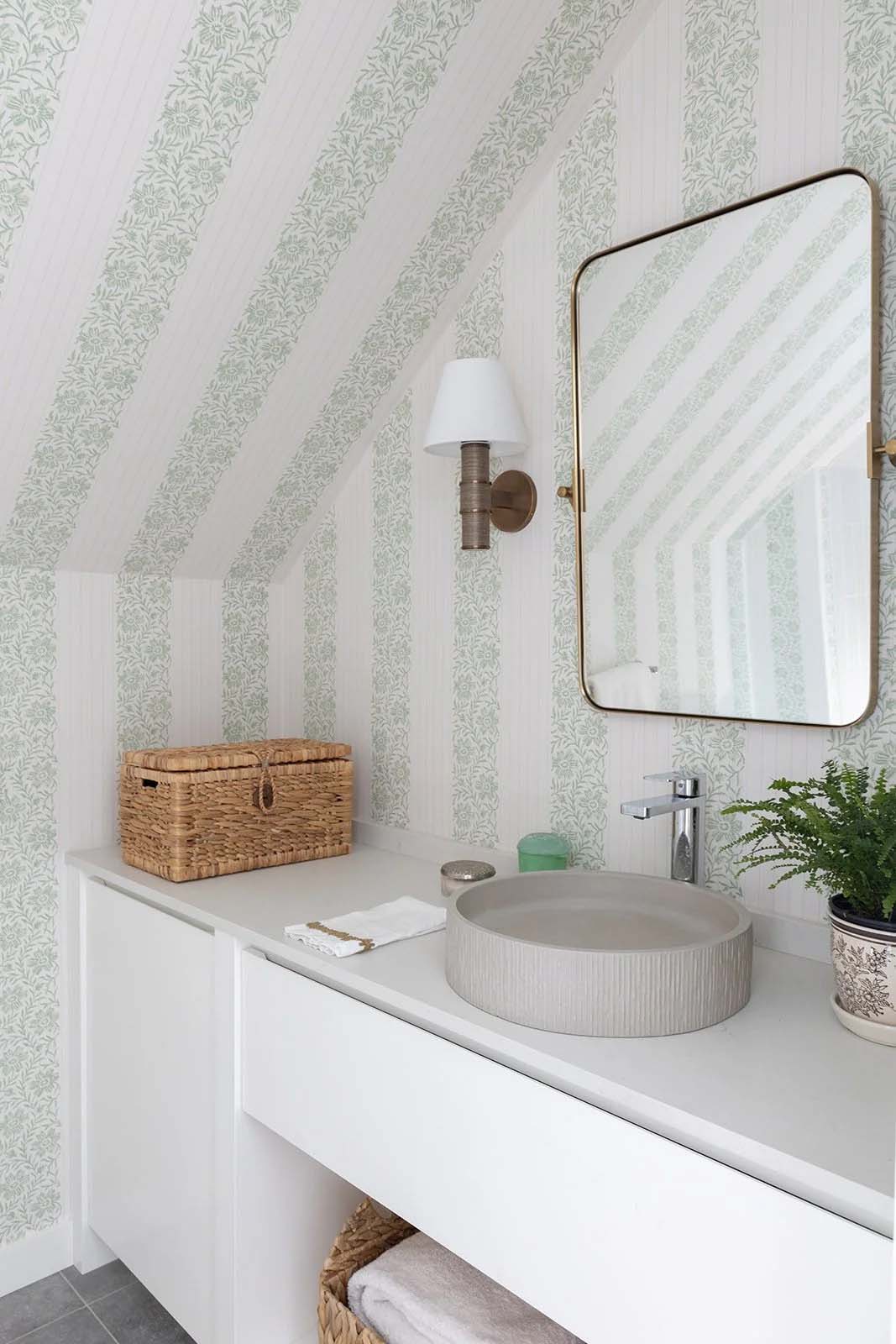 Powder room with green floral striped wallpaper, a round concrete vessel sink and brass mirror