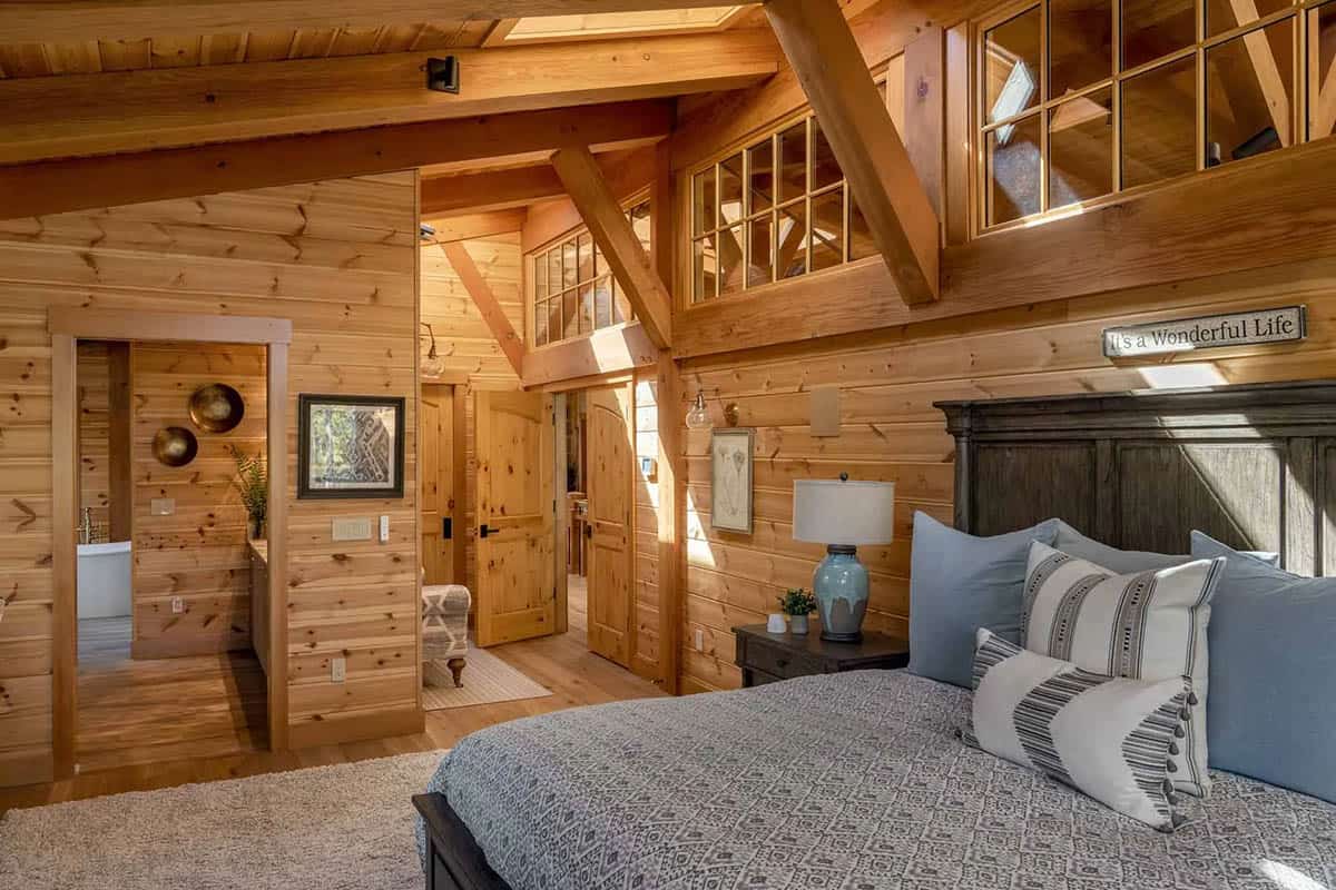 Bedroom with pine-paneled walls, interior clerestory windows, and a view into the bathroom