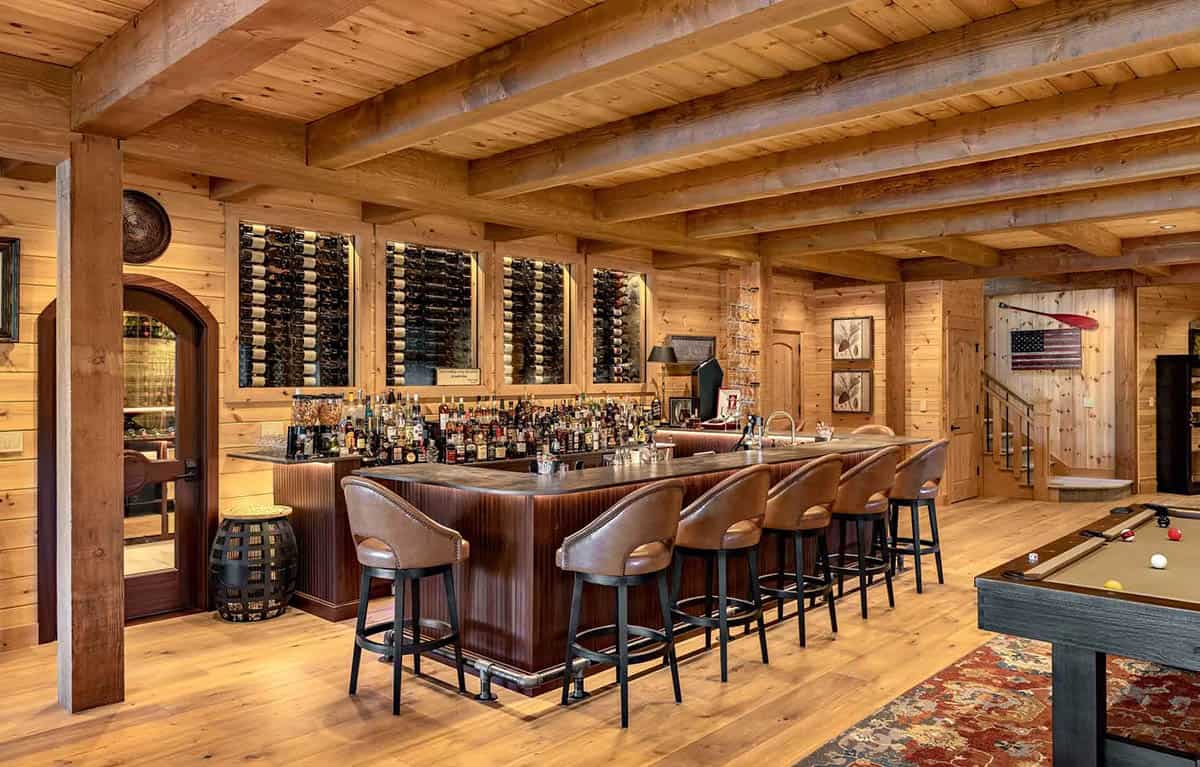 Lower-level wet bar with leather stools, backlit wine display wall, and pool table