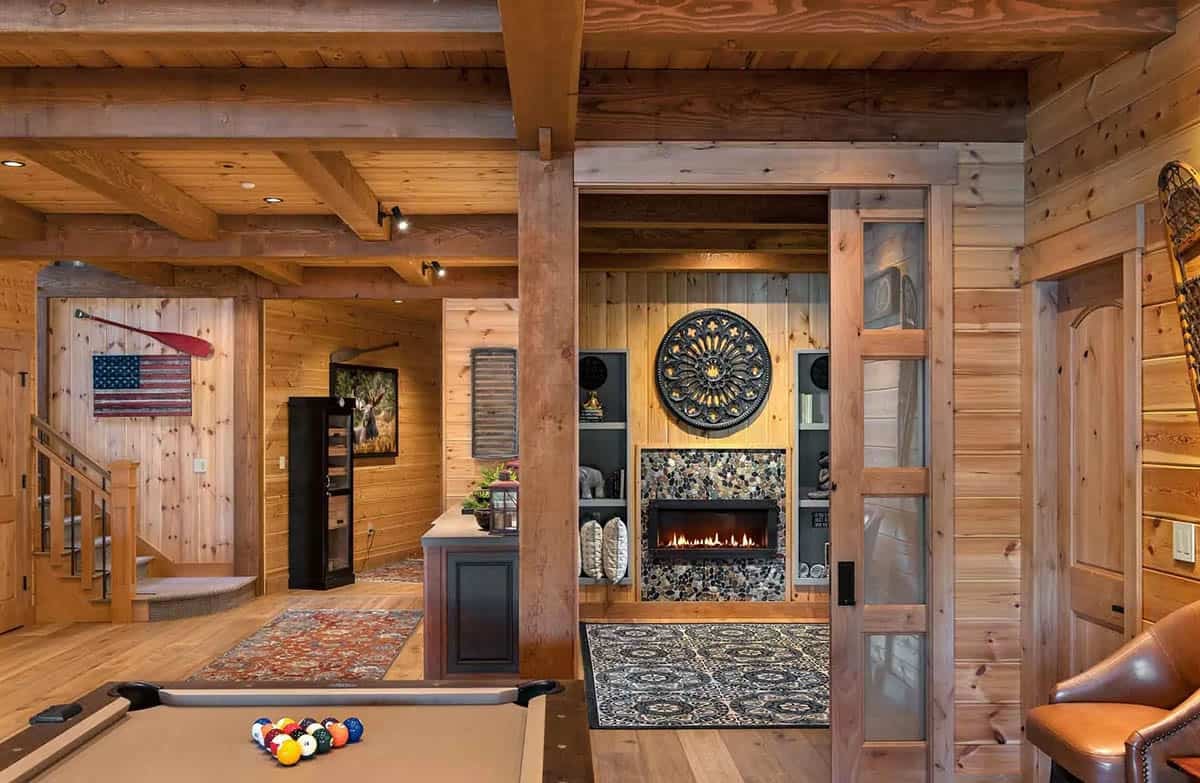 Game room with pool table opening to a TV nook with a pebble tile fireplace