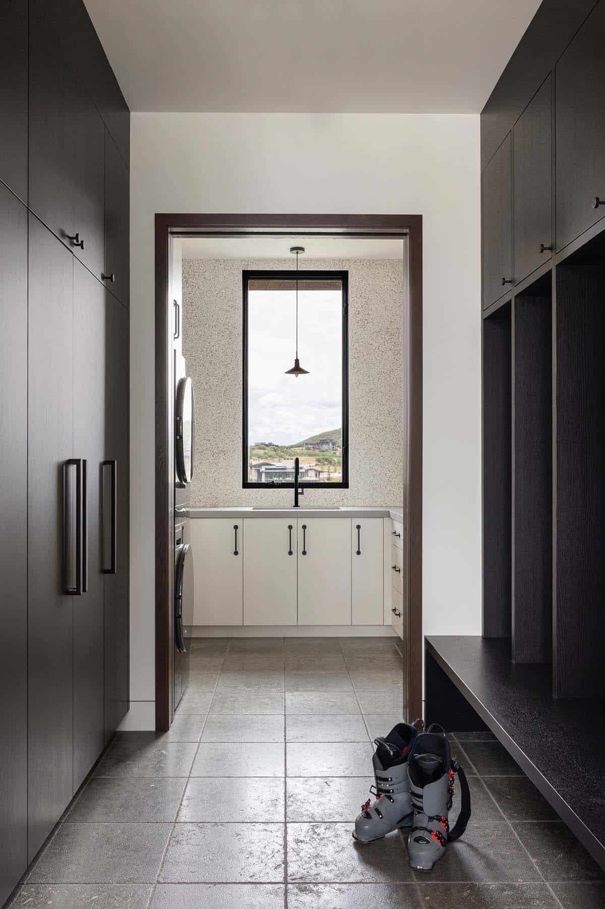 Mudroom with dark oak lockers leading to laundry room with window