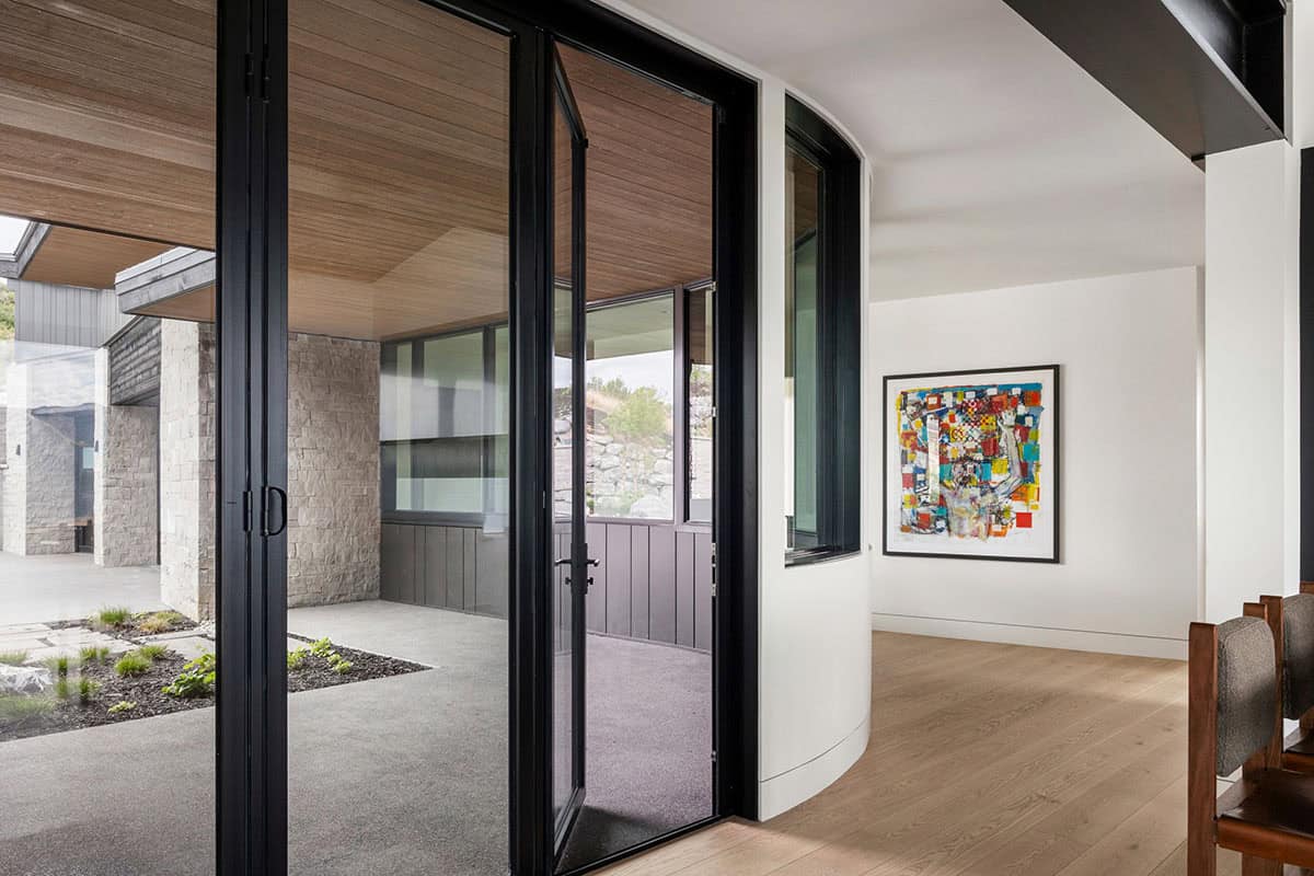 Glass entry vestibule with curved white wall and colorful abstract painting