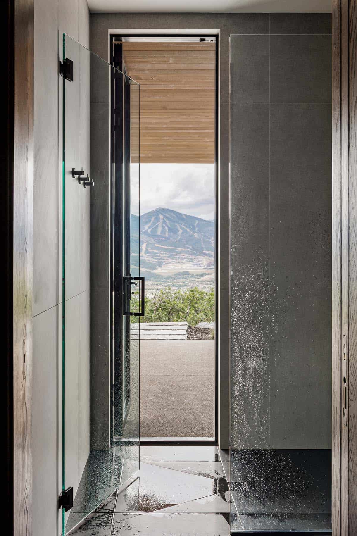 Glass shower with door opening to outdoor patio and mountain view