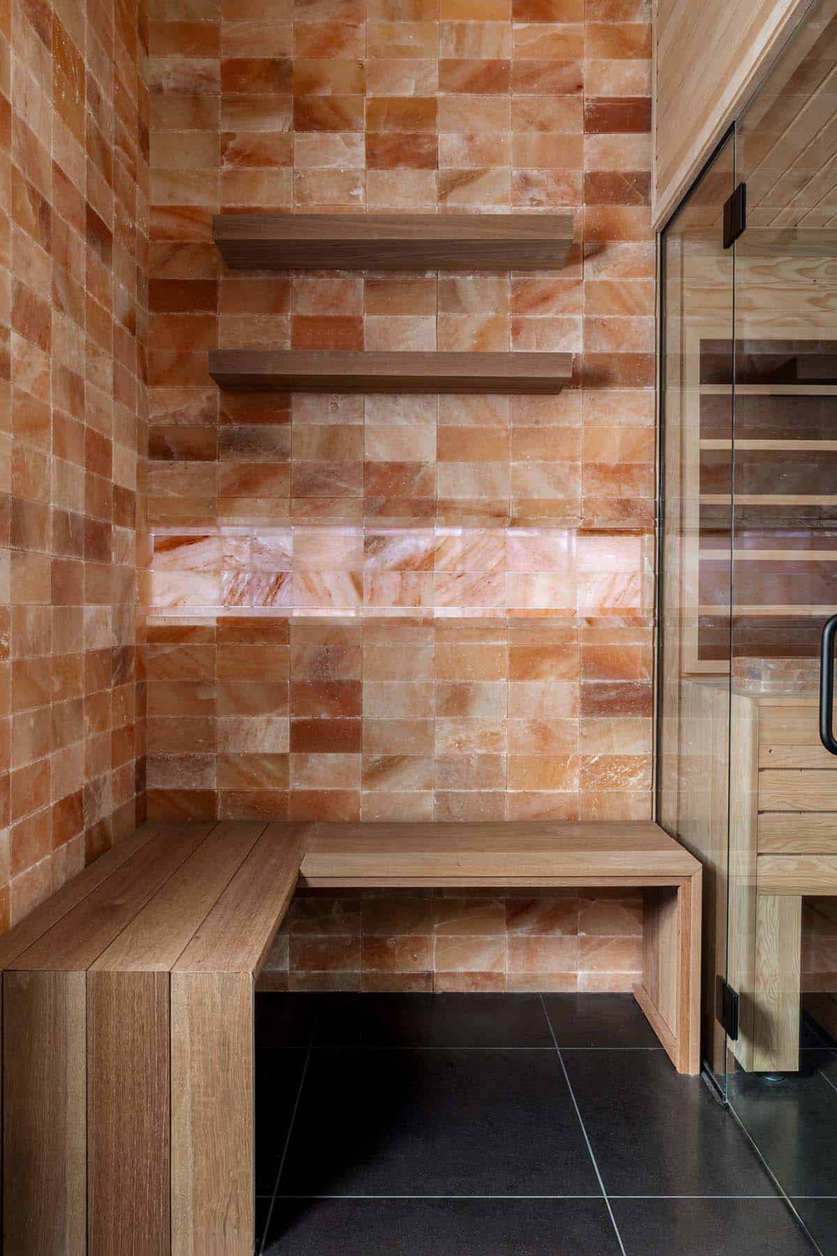 Wood bench and floating shelves against glowing Himalayan salt block wall
