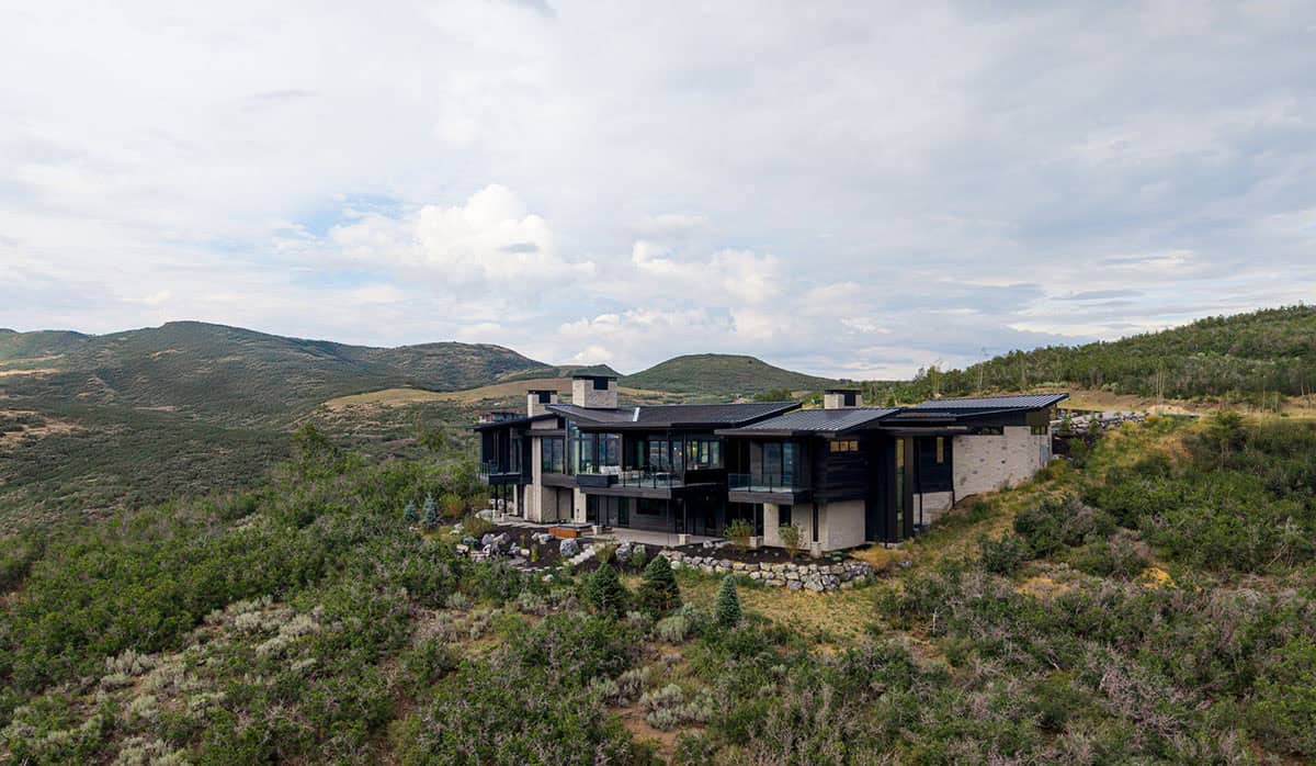 Aerial view of modern mountain home on hillside surrounded by scrub oak