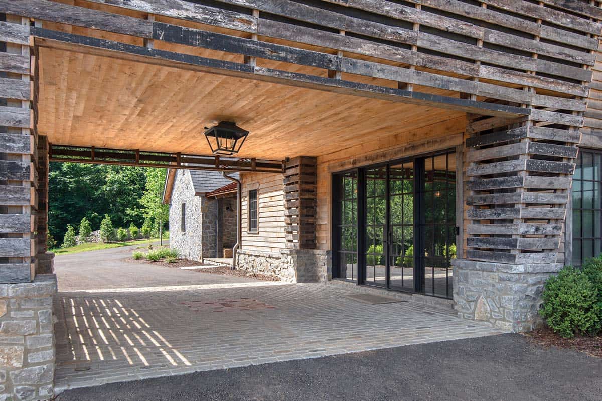 Slatted wood porte-cochere with cobblestone paving and lantern