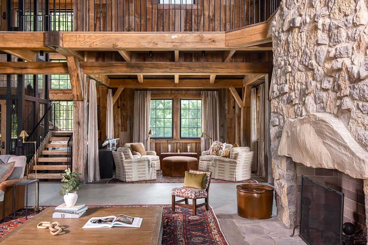Sitting area beneath loft with striped armchairs and linen curtains