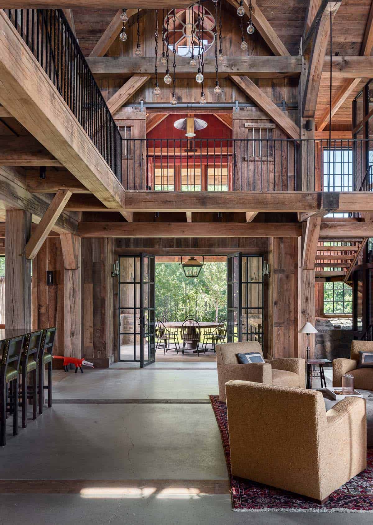 Steel doors open to covered dining porch below loft balcony