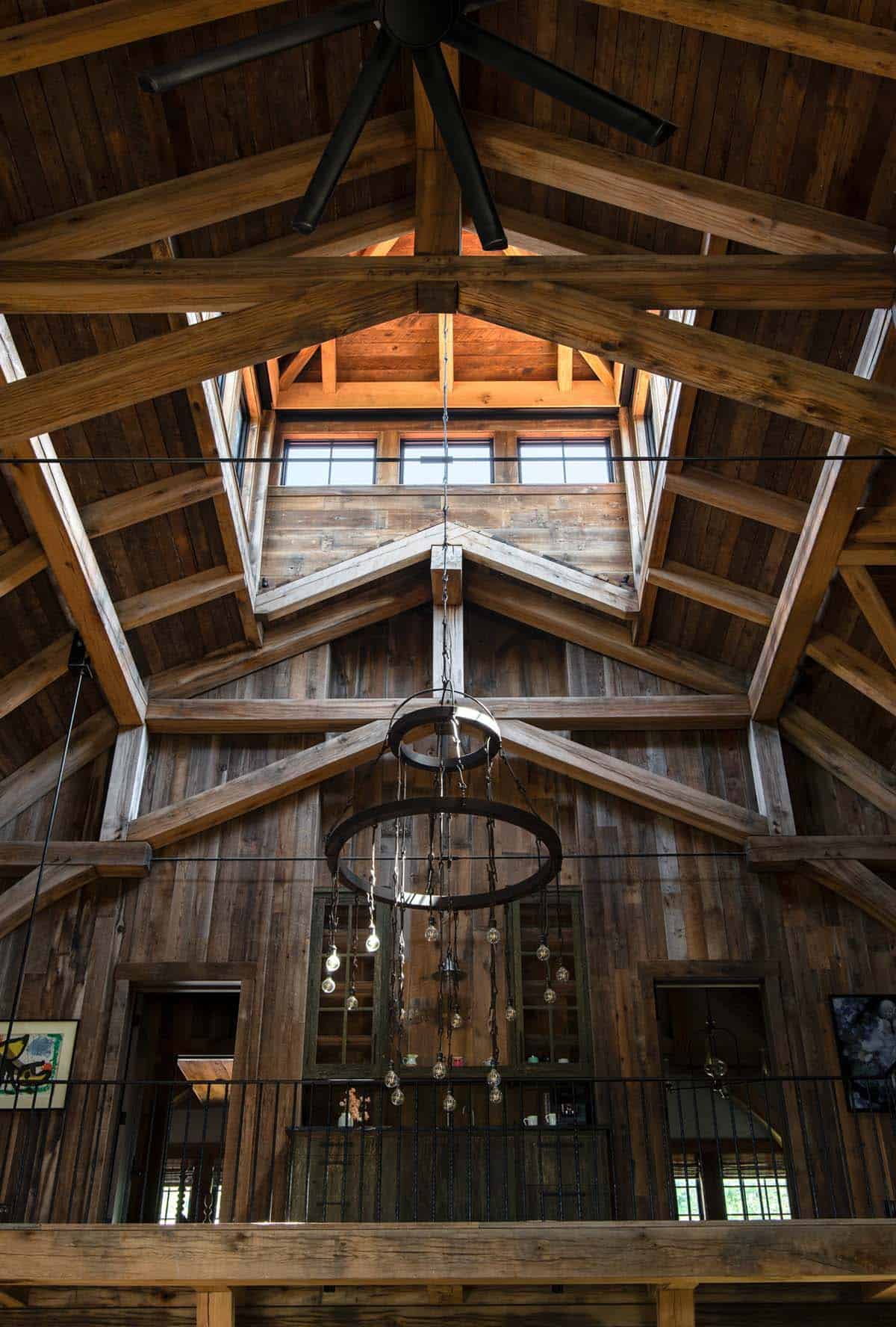 Timber trusses rising to clerestory cupola above iron chandelier