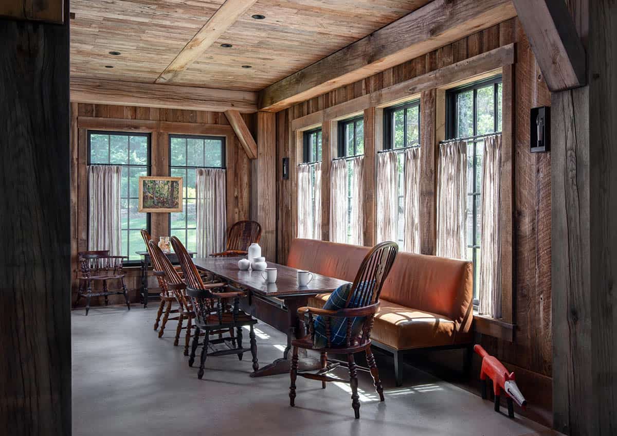 Dining nook with Windsor chairs and leather banquette under windows