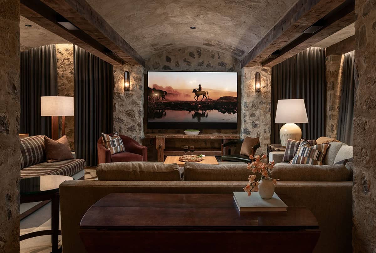 Media room with barrel-vaulted stone ceiling and velvet drapes