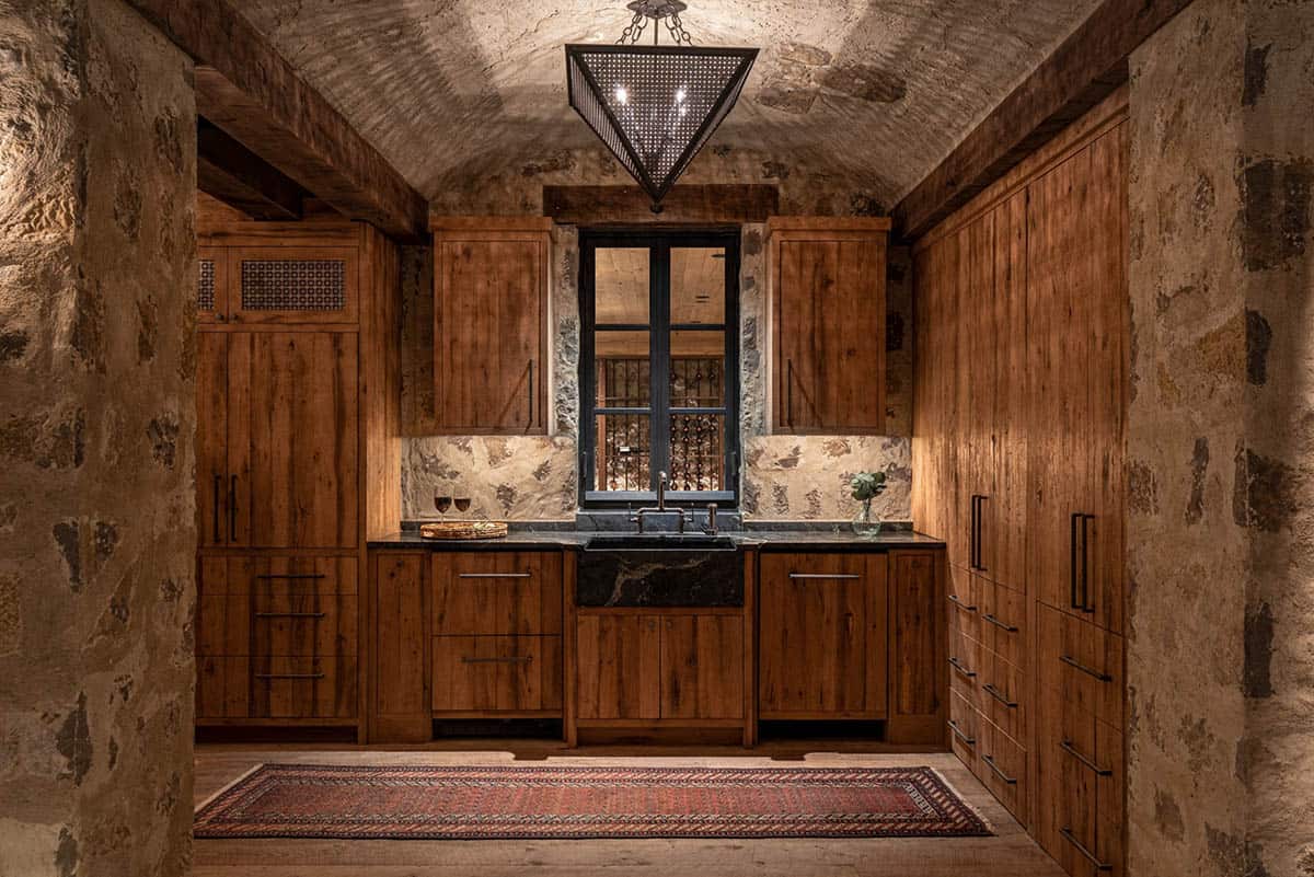 Bar with reclaimed oak cabinets and window into wine cellar