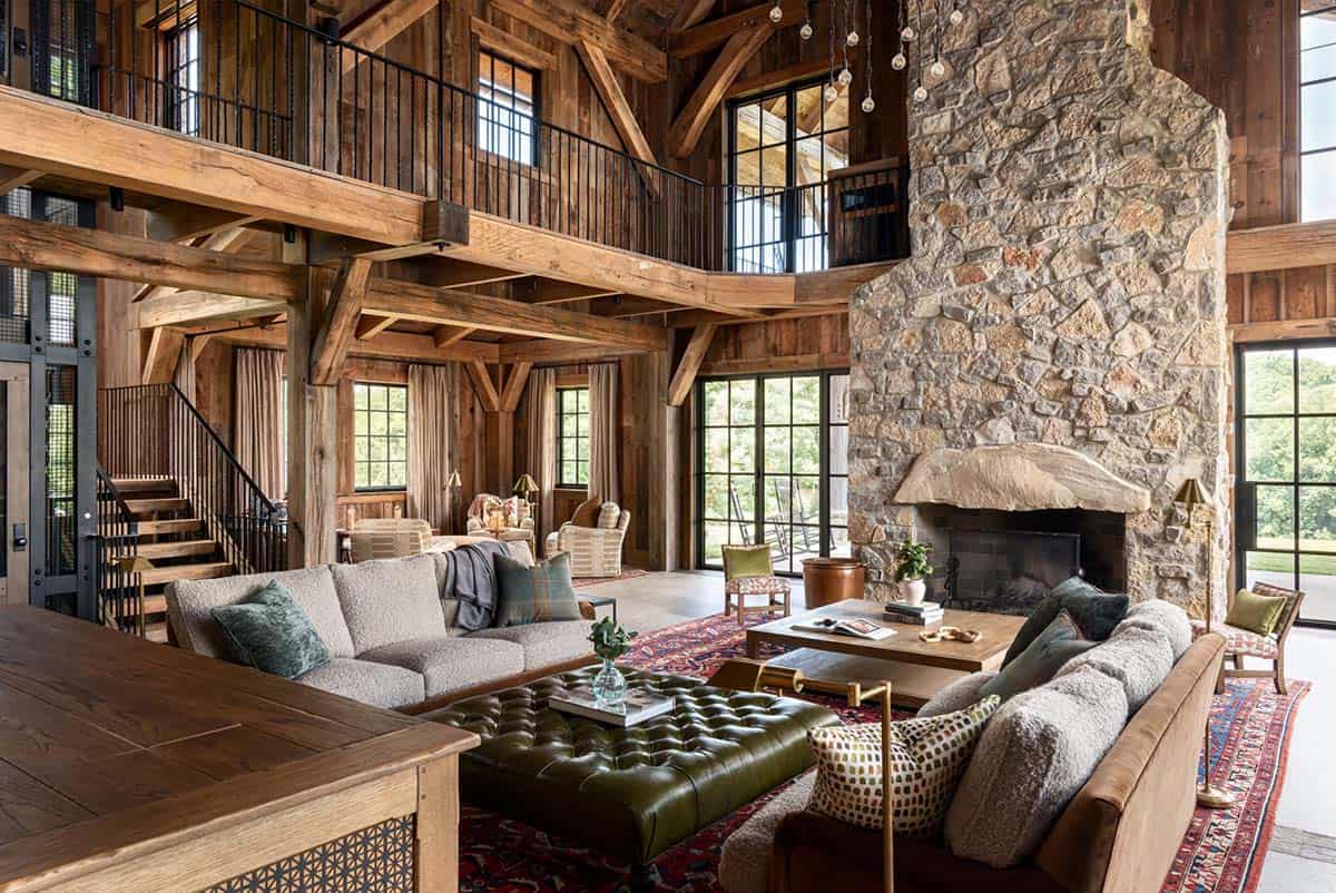 Great room with stone fireplace, boucle sofas, and loft balcony