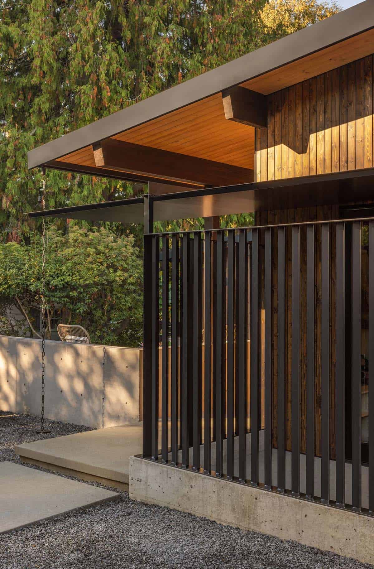 Black steel slat screen beneath deep roof overhang with exposed wood beams