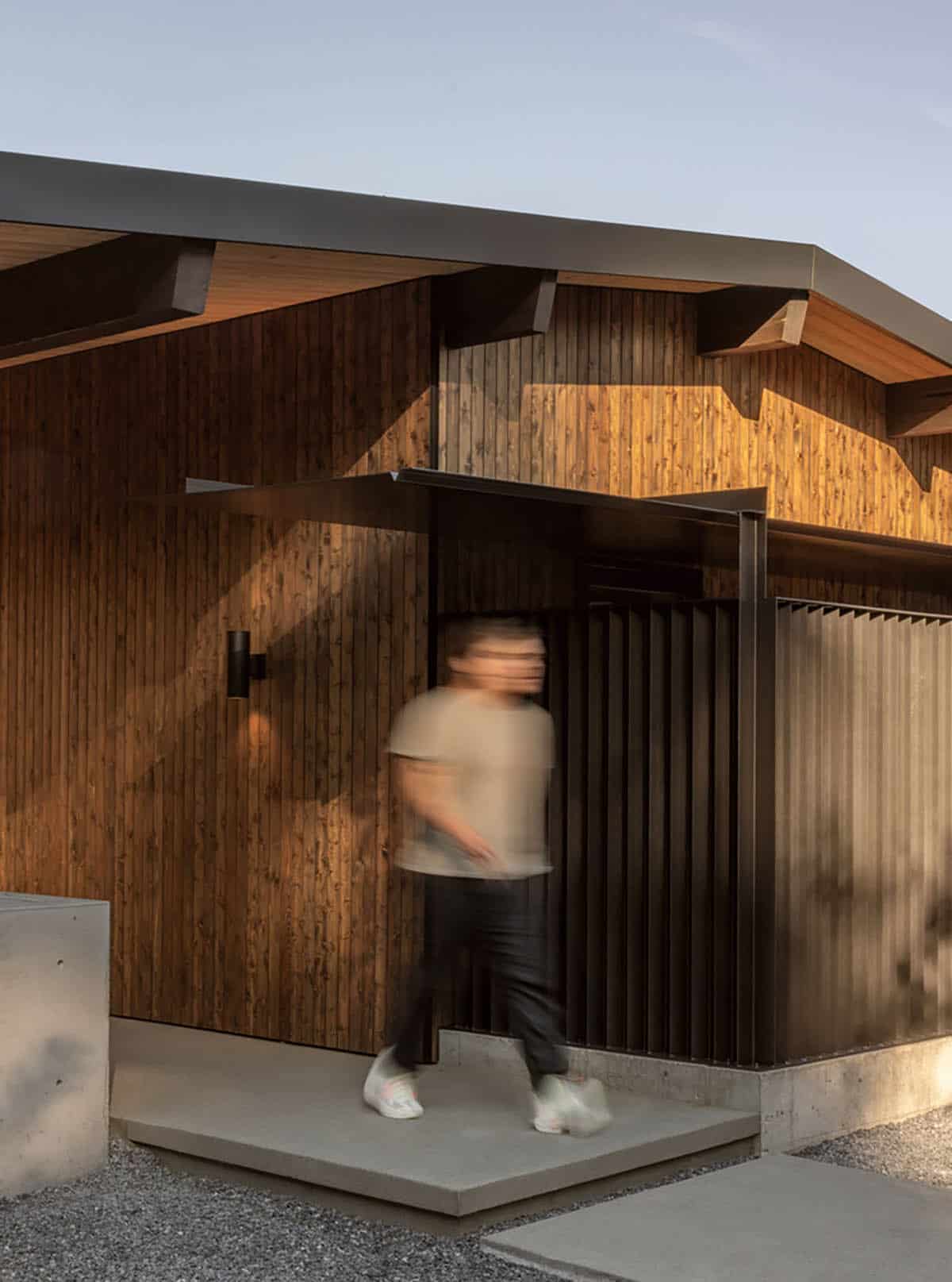 Person walking past steel slat screen at front entry