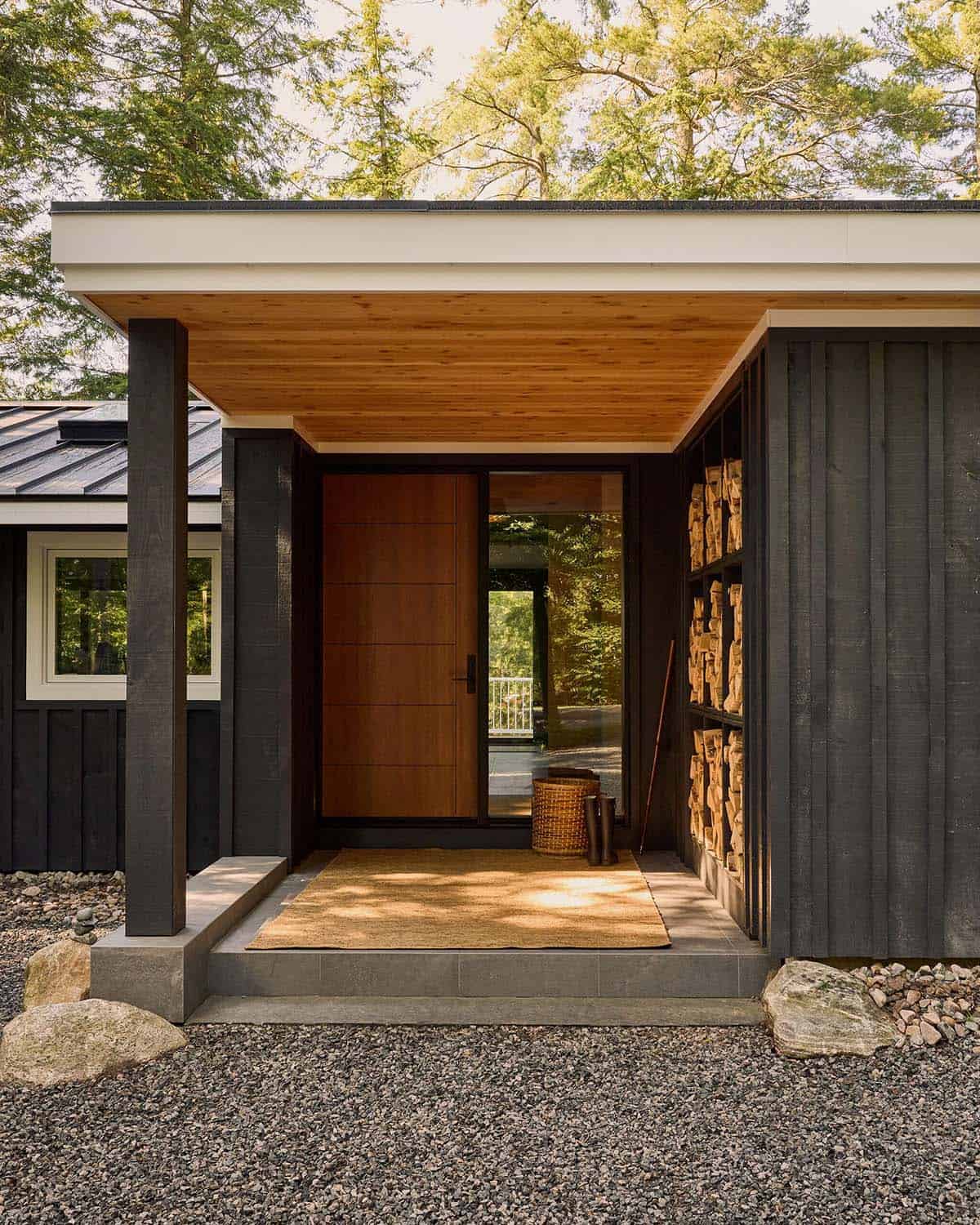 Covered front entry with wood door and stacked firewood