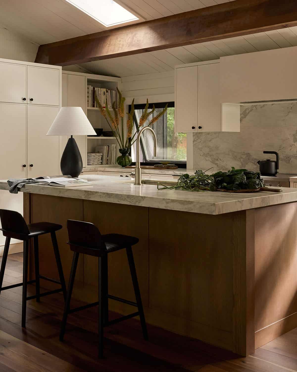 Kitchen with wood island, stone countertops, and black stools