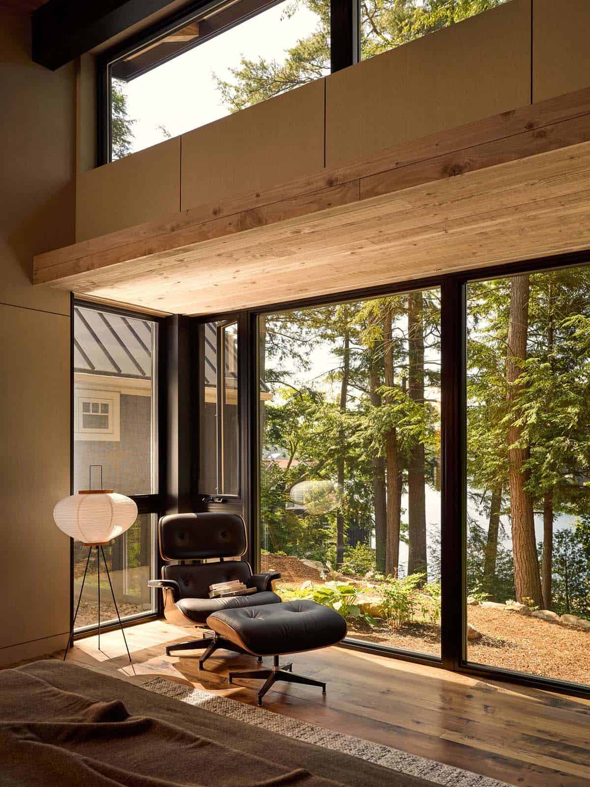 Eames lounge chair by floor-to-ceiling bedroom windows