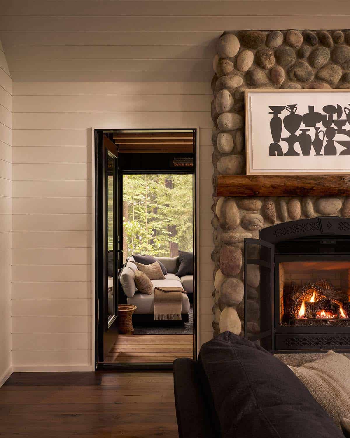 River rock fireplace with doorway to the screened porch