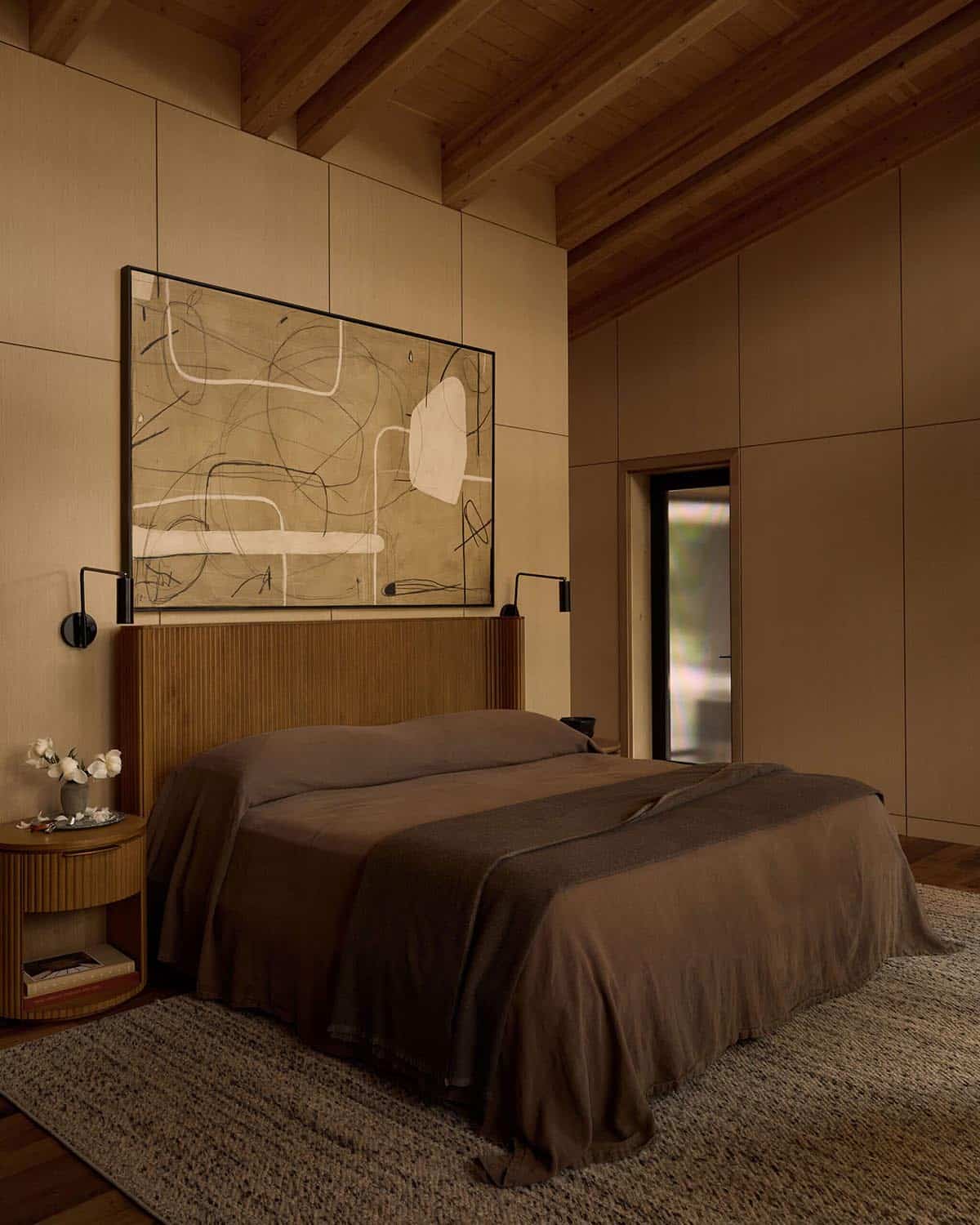 Primary bedroom with fluted headboard and abstract artwork