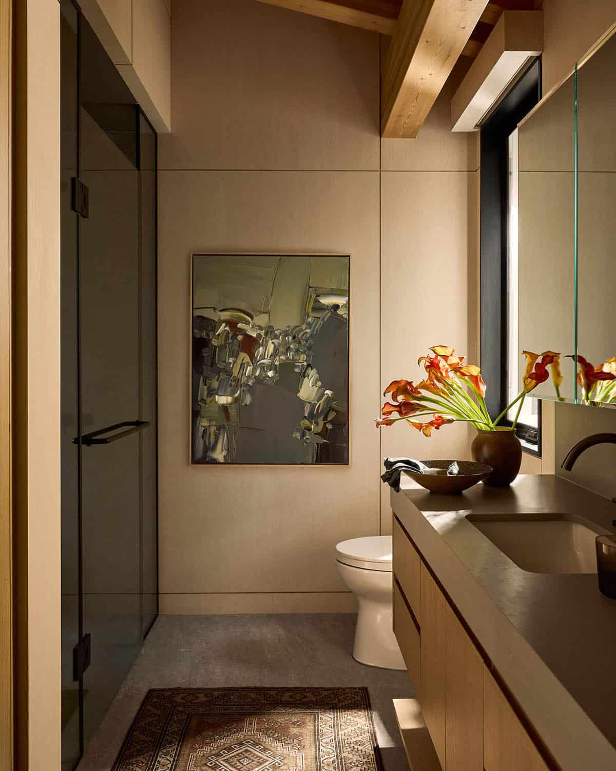 Ash-paneled bathroom with abstract painting and glass shower