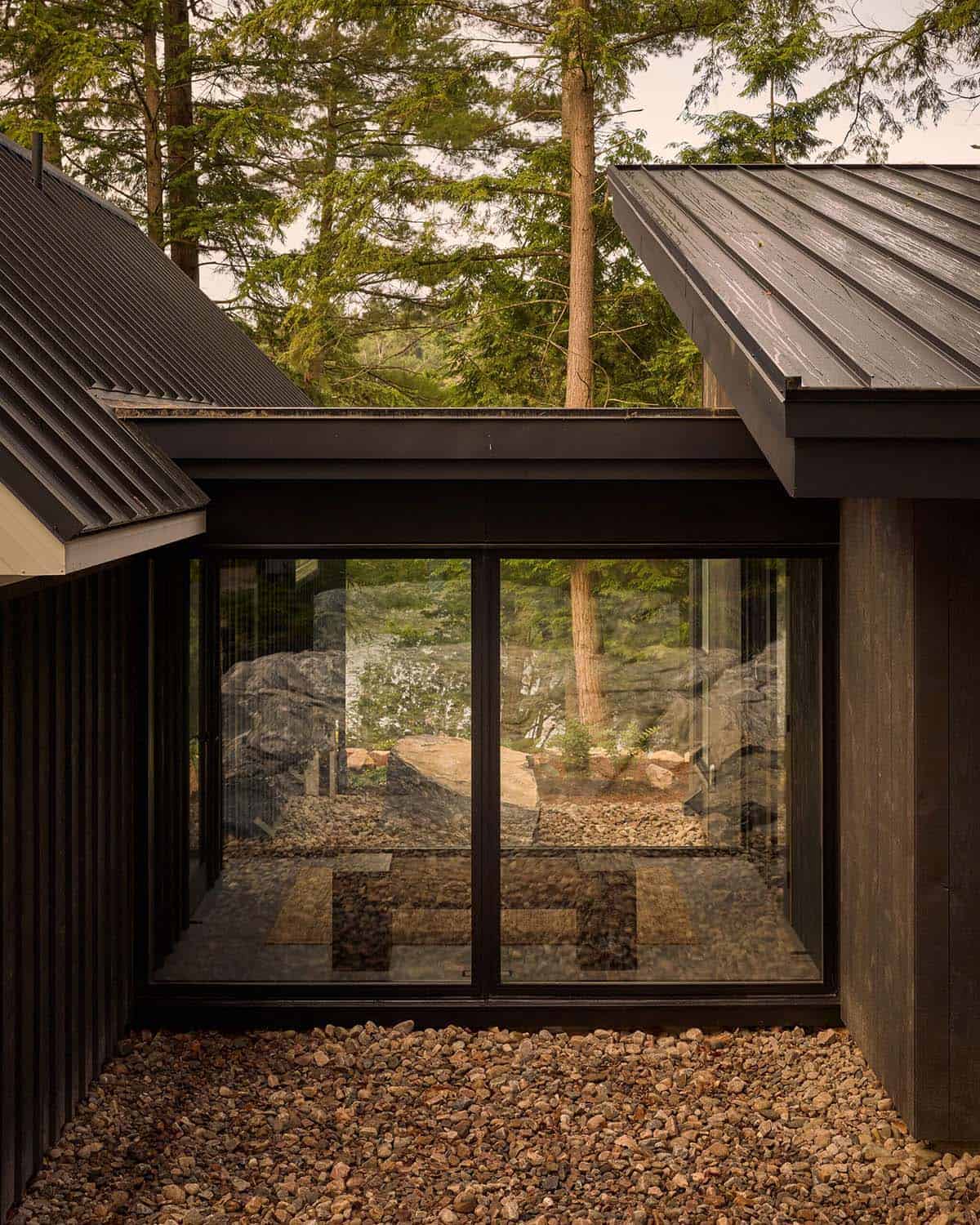 Glass connector between cottage wings with gravel courtyard