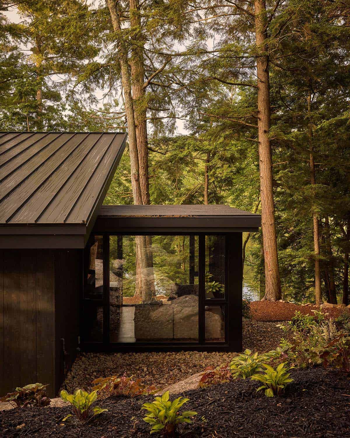 Glass-walled sitting room addition beside a metal roof