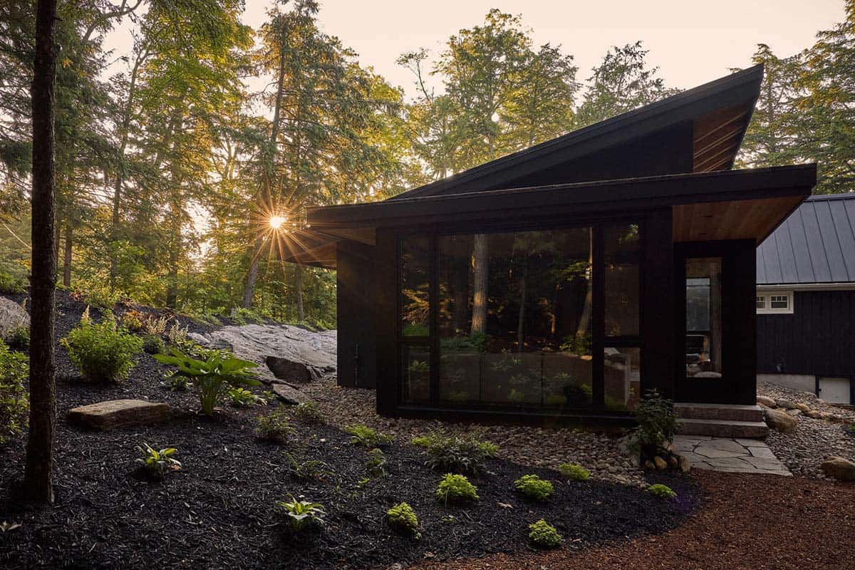 Glass sitting room addition with sun through the trees