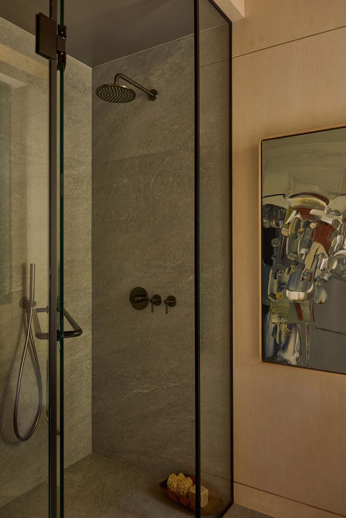 Walk-in shower with stone walls and bronze fixtures
