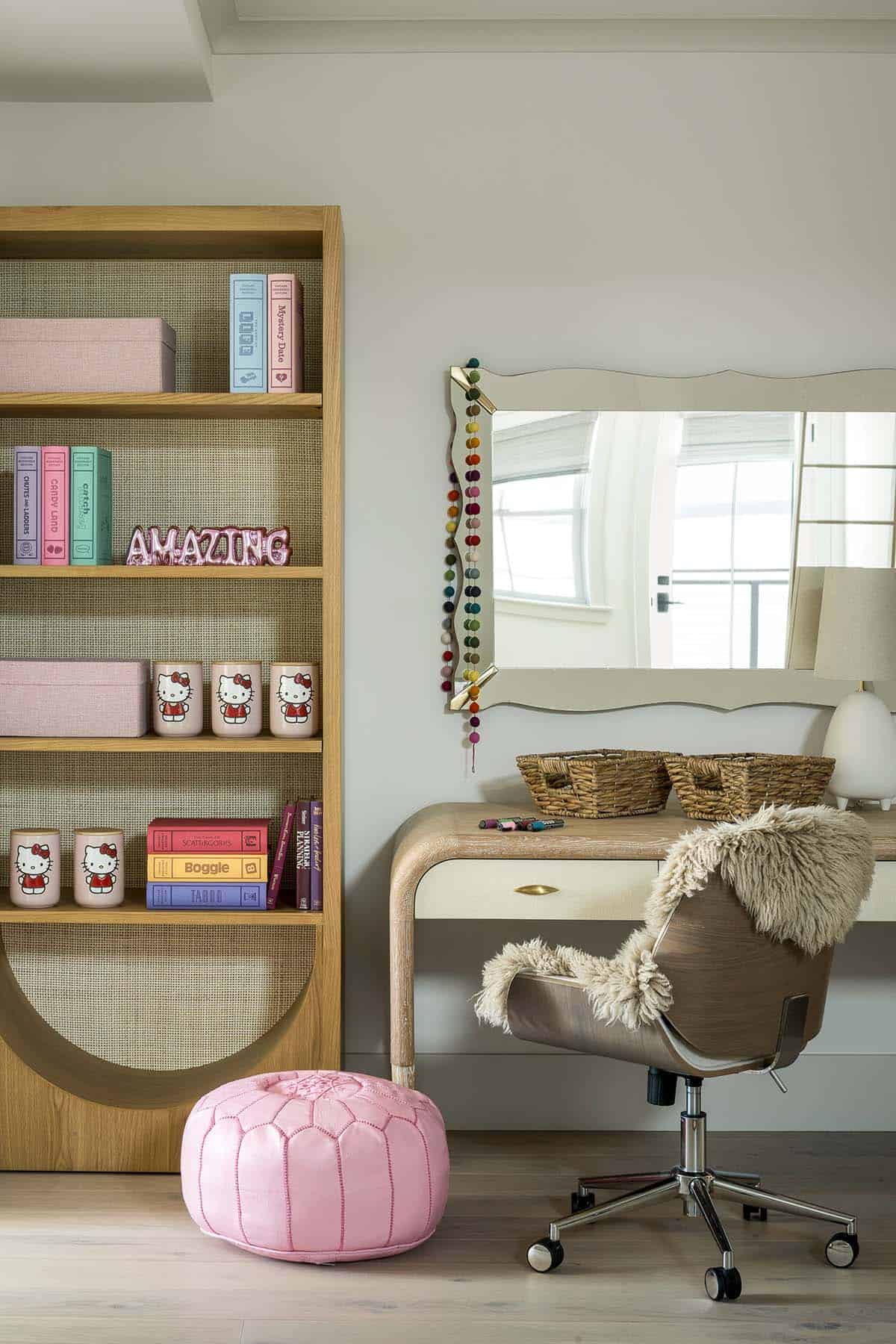 Girl's bedroom with oak bookcase with cane backing, scalloped mirror, curved desk, and pink leather pouf
