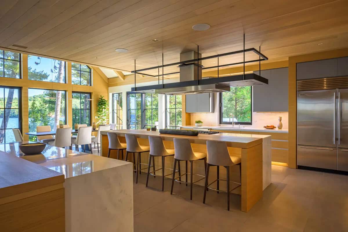 Kitchen with a five-stool island, suspended range hood, and a stainless steel refrigerator