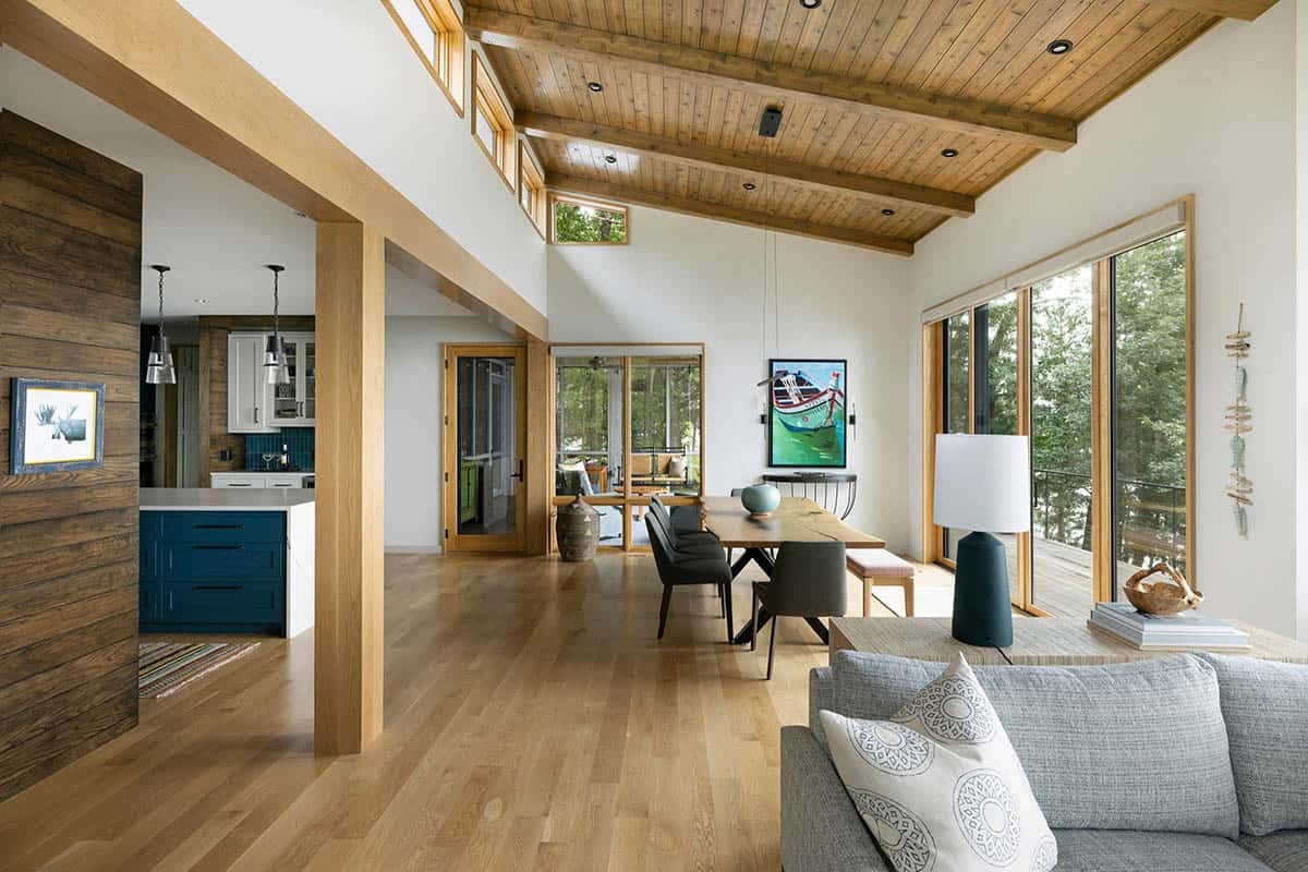 Dining area with a live-edge table, boat artwork, and sliding doors to the deck
