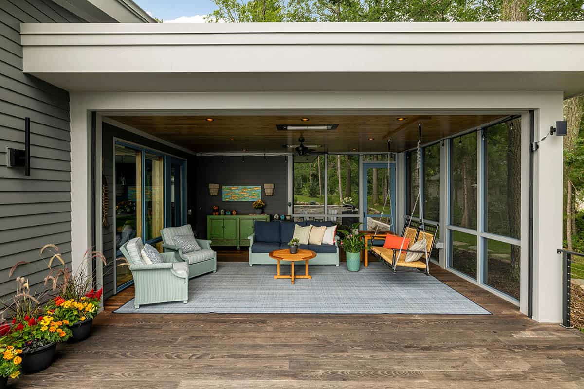 Screened porch with a porch swing, green console, and a lounge area over a wood deck