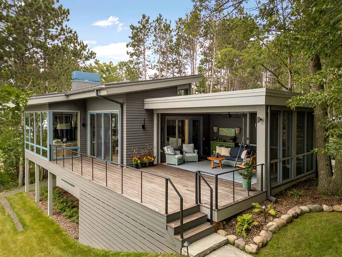 Aerial view of the deck, covered porch with swing, and stone-edged garden bed