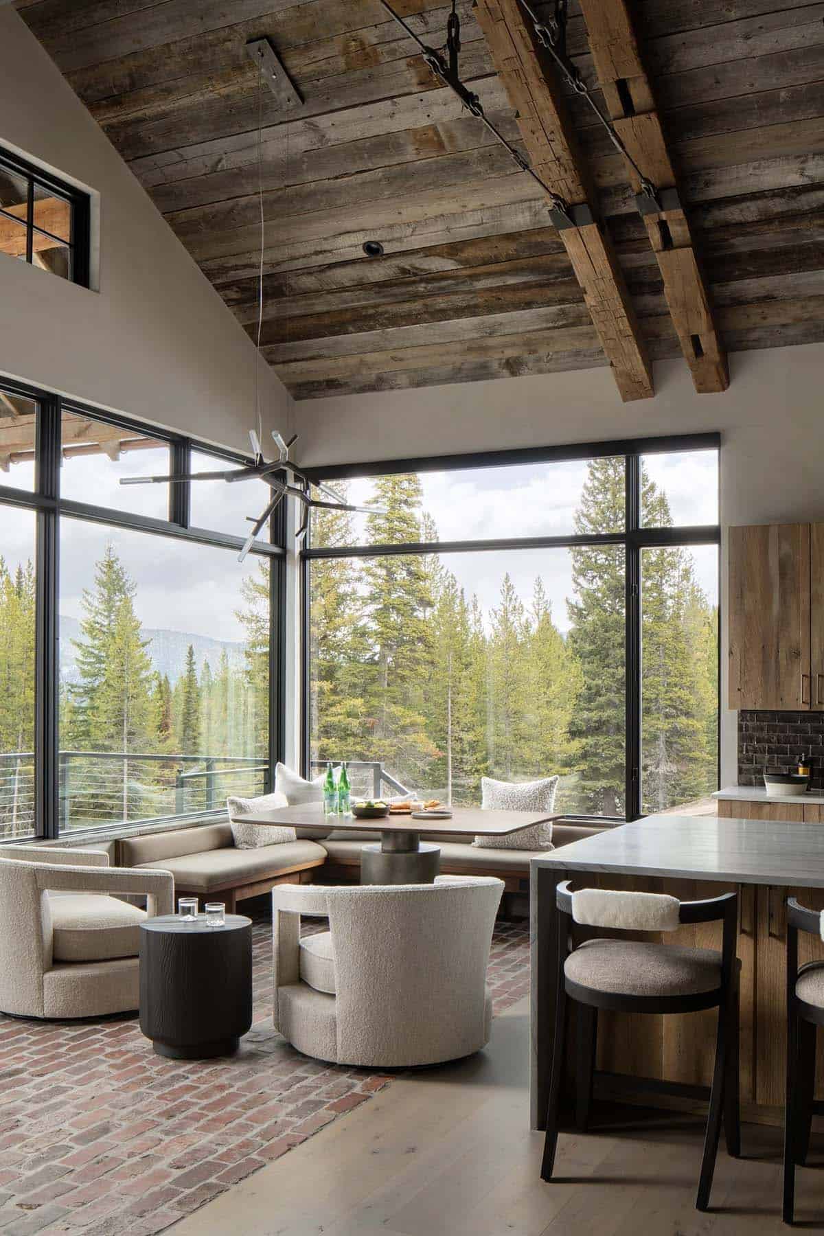 Breakfast nook with a banquette, swivel chairs, and brick floor under a wood ceiling