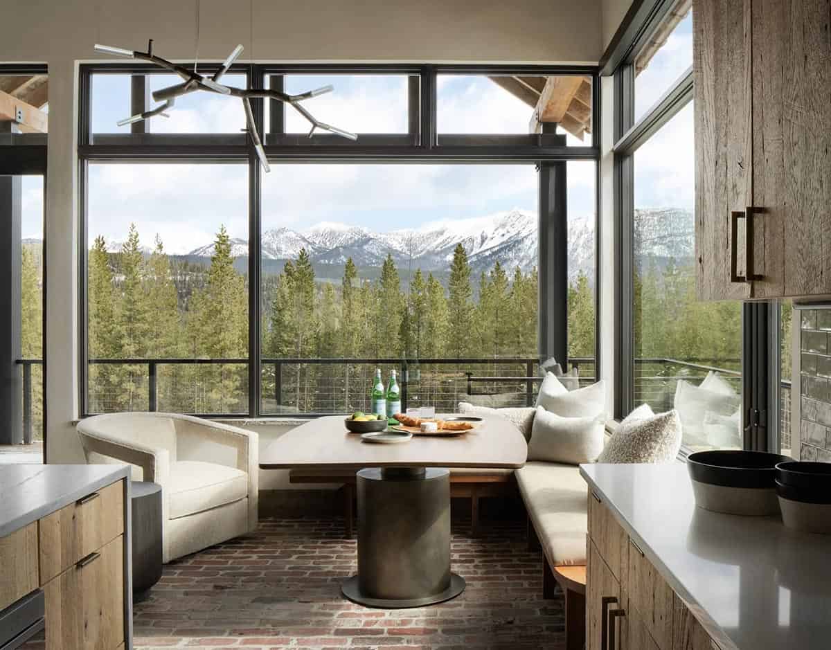 Breakfast nook with a pedestal table and windows facing snowy mountain peaks