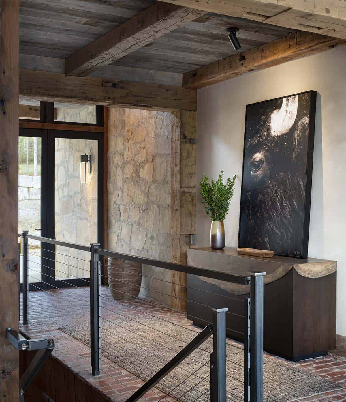 Entry landing with brick floor, stone wall, cable railing, and a bison photo