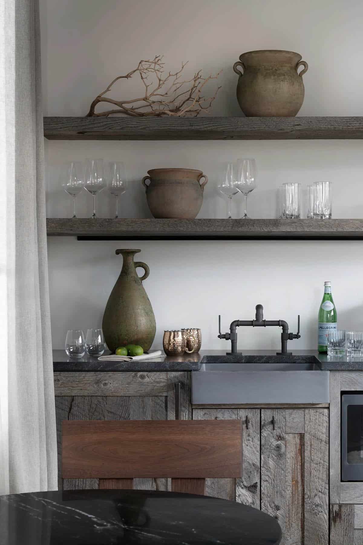 Kitchenette with reclaimed wood cabinets, concrete sink, and open shelves