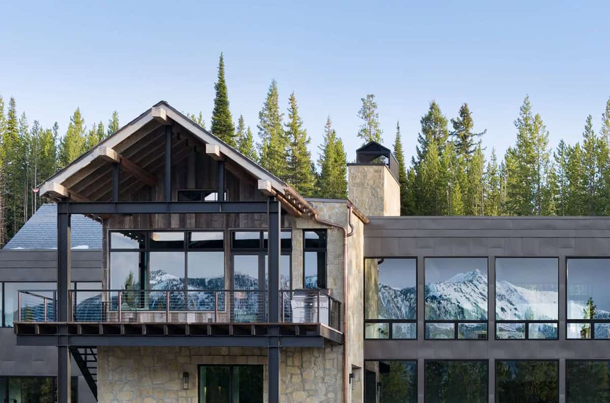 Covered deck with steel posts and windows reflecting snowy peaks