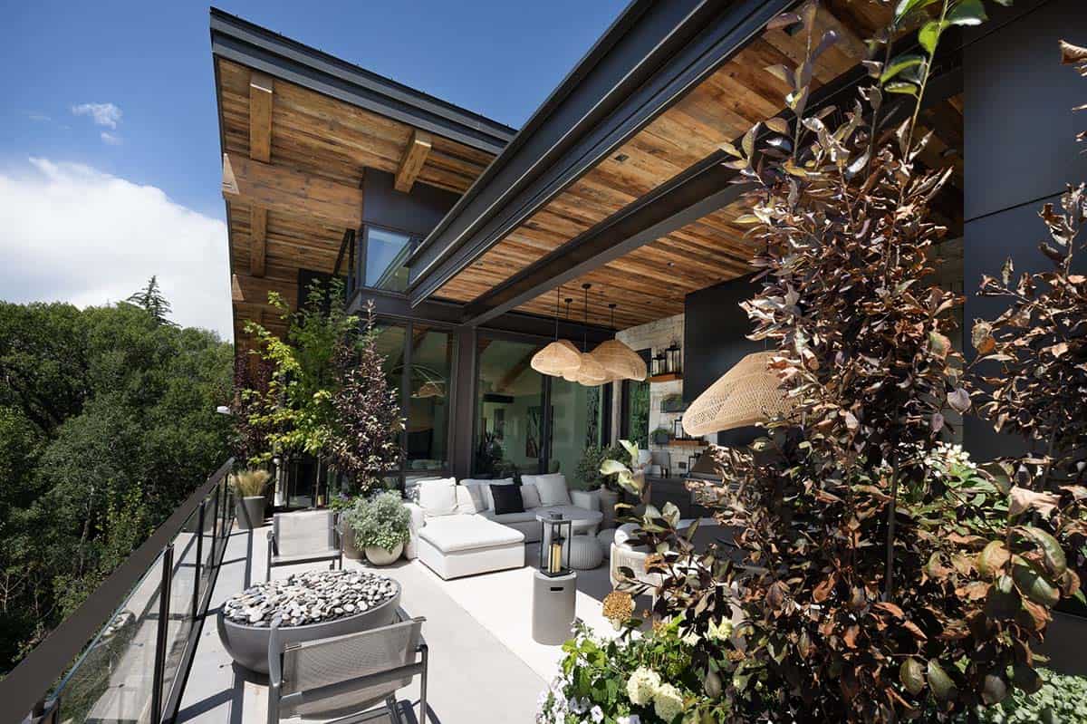 Covered terrace with reclaimed wood ceiling, wicker pendants, and white lounge seating